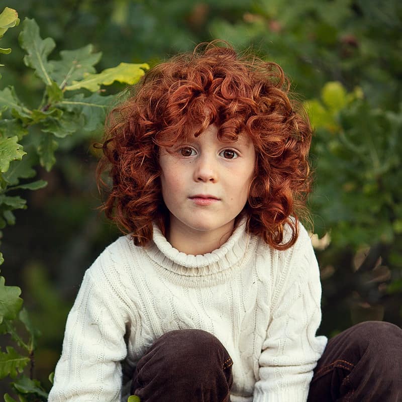 ragazzo con lunghi capelli rossi ricci